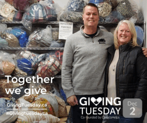 Husband and wife standing in front of bags of donated clothing